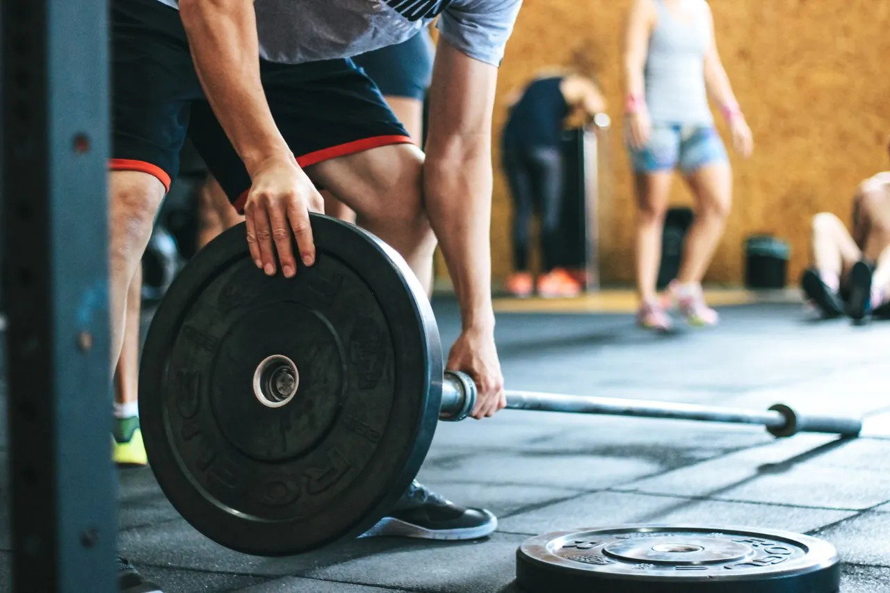 A lifter gripping a loaded Olympic barbell