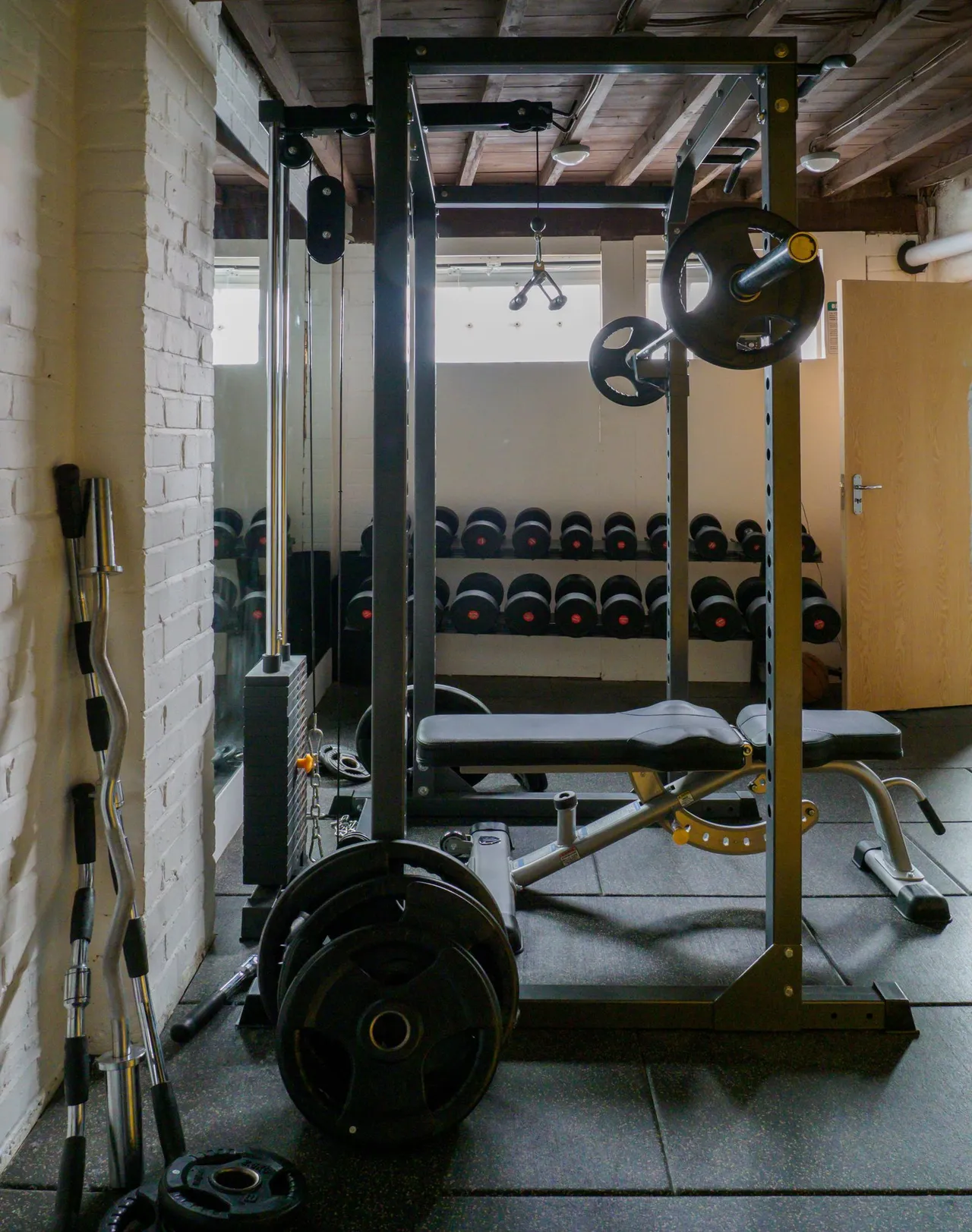 Barbells and weight plates racked in a gym