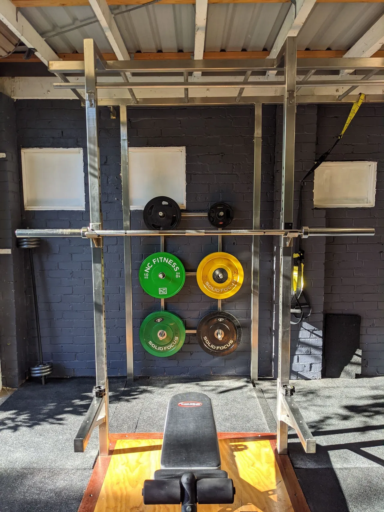 Weight plates and a barbell arranged on the gym floor