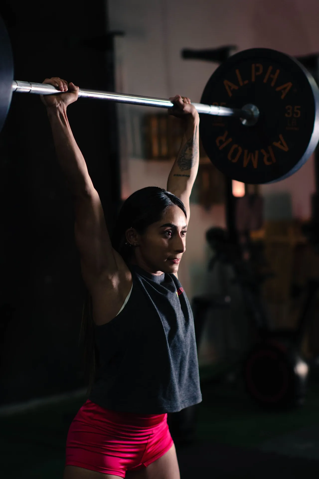 A woman lifting a barbell in the gym
